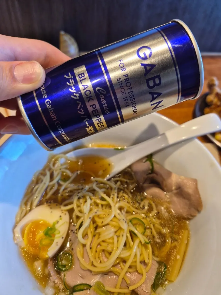 Adding pepper to the motsu ramen