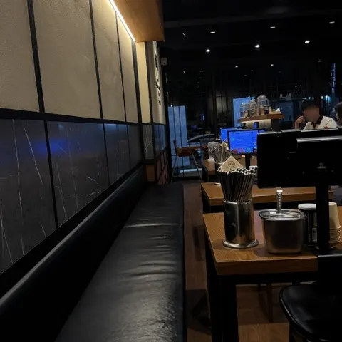Bar seating in front of the kitchen and tables further inside
