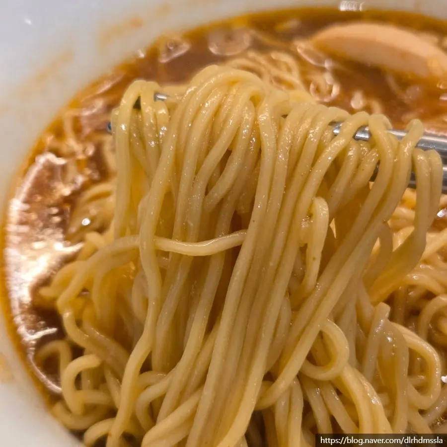 Two bowls of ramen comparing regular and spicy broth