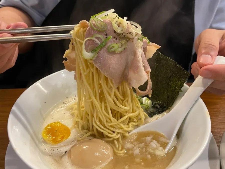 Taking a bite of noodles wrapped in nori