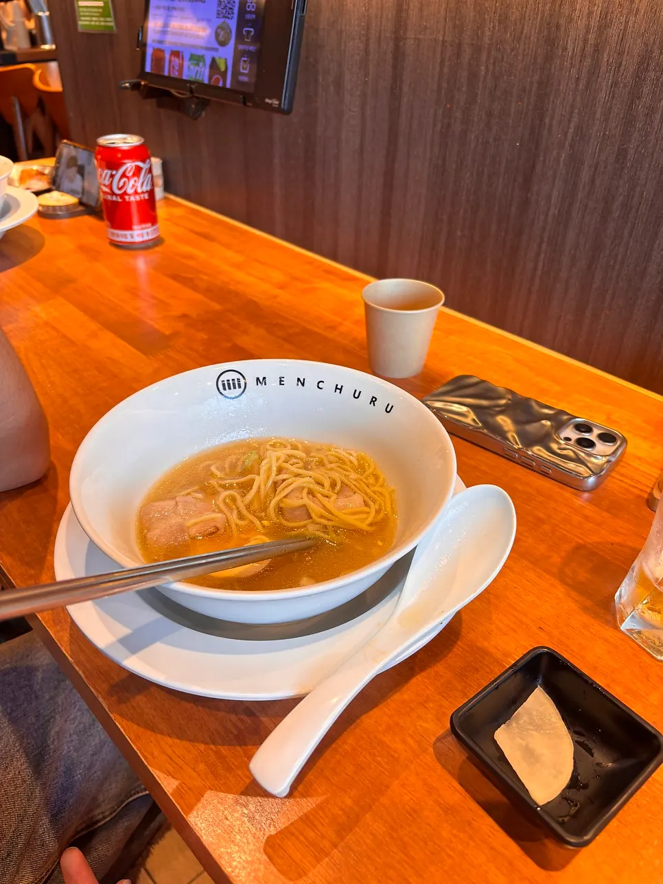 A spoonful of ramen broth lifted up