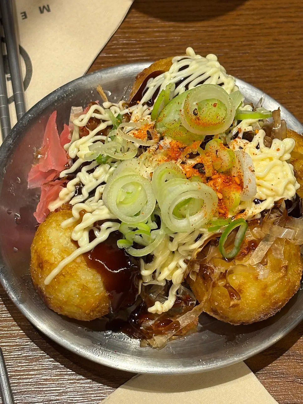 Five pieces of takoyaki topped with bonito flakes