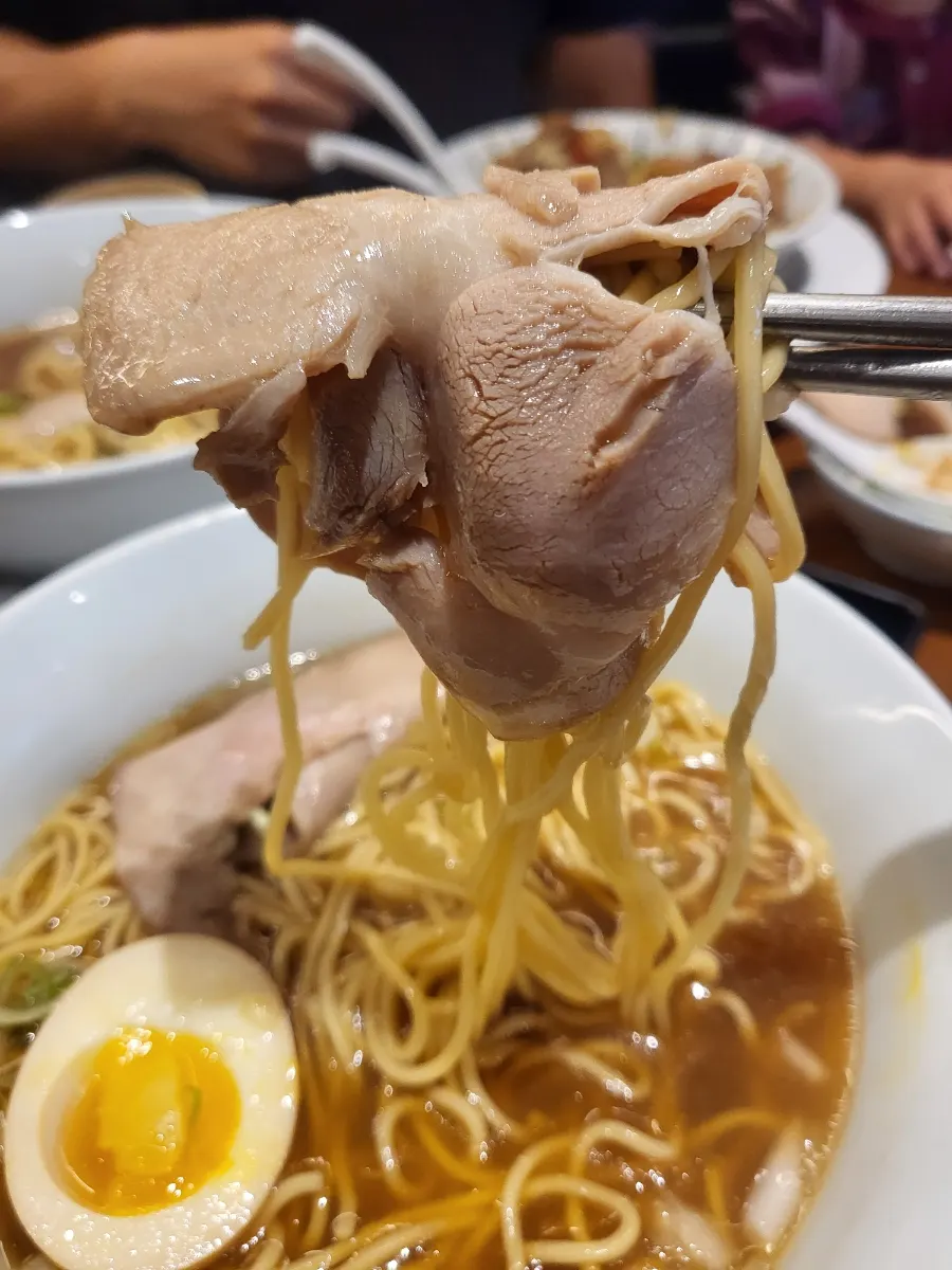 Soyu ganjang ramen topped with meat and scallions