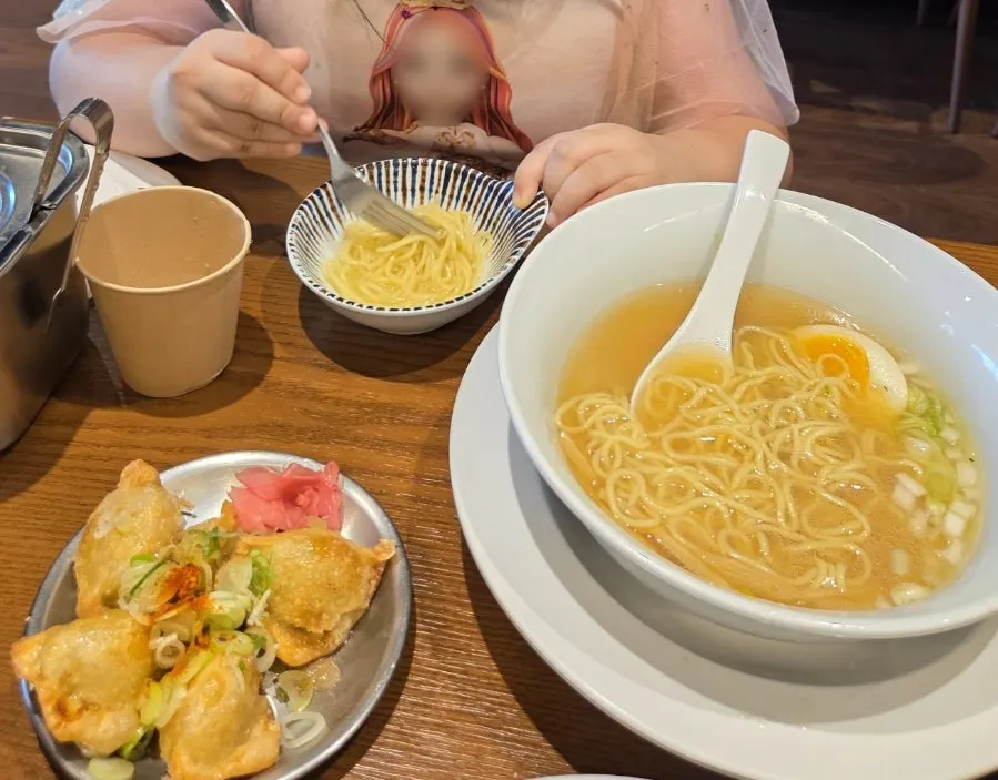 Shio ramen ladled into a bowl for the child