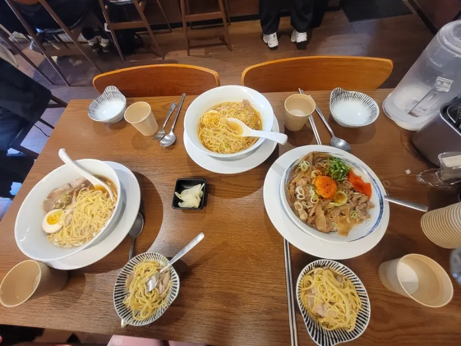 Spicy shoyu ramen noodles lifted with chopsticks
