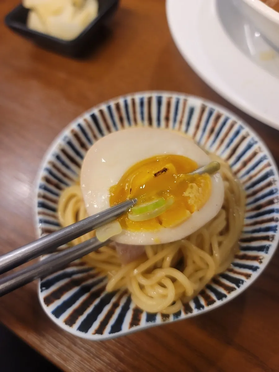 A bite of ramen with soft meat topping