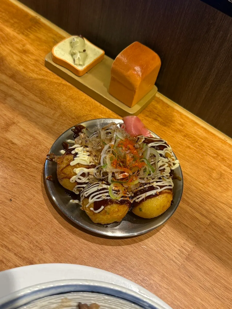Table spread of Mentsuru's takoyaki, ramen and gyudon