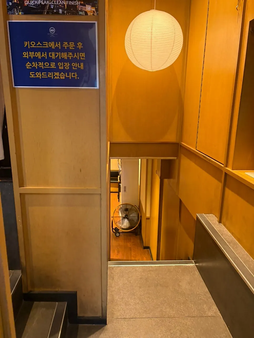 Store entrance with kiosk ordering sign and paper lantern