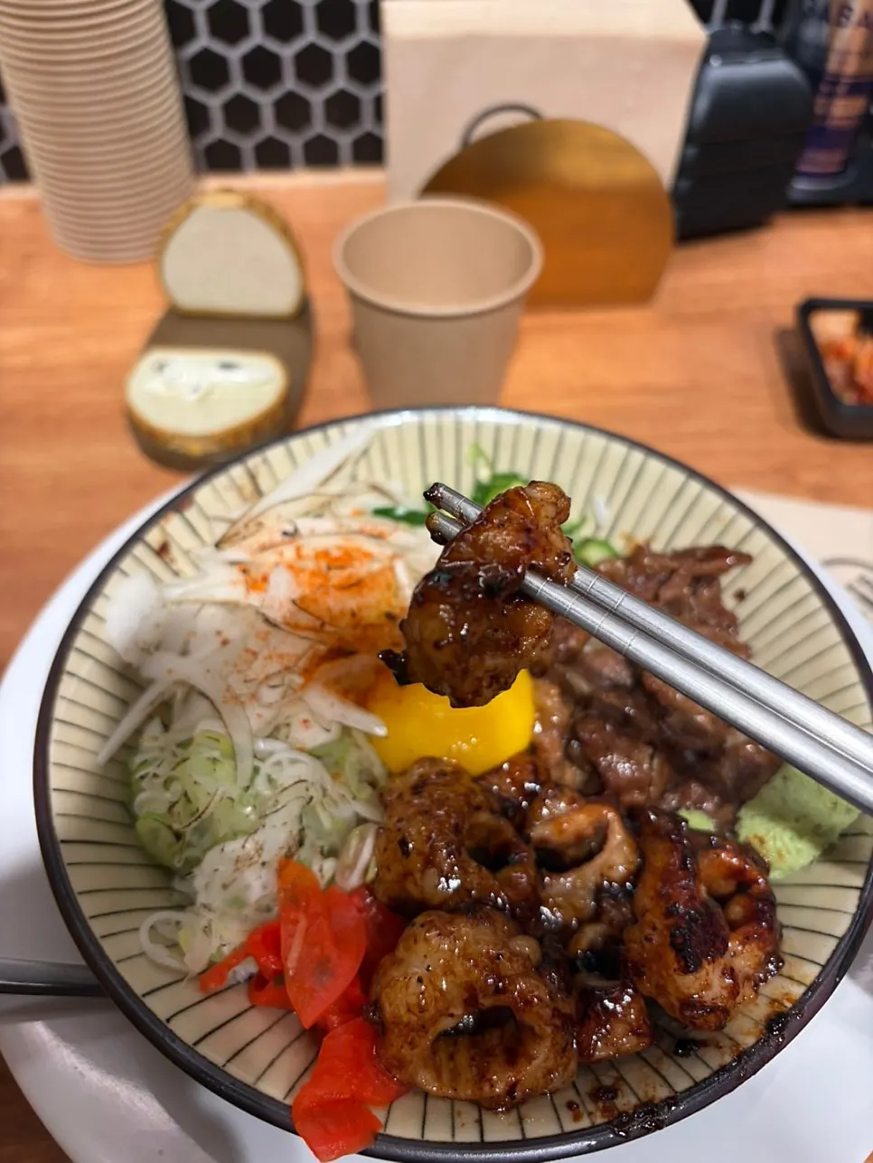 A piece of seasoned beef intestine lifted with chopsticks