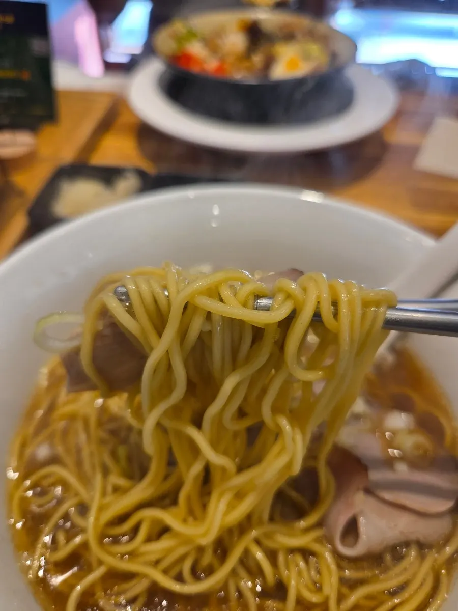 Toppings de menma y cebollín sobre el ramen