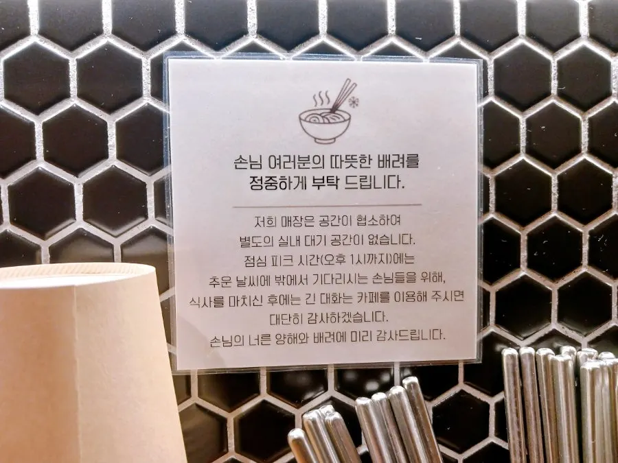 Kimchi, water, chopsticks, and tissues on the table