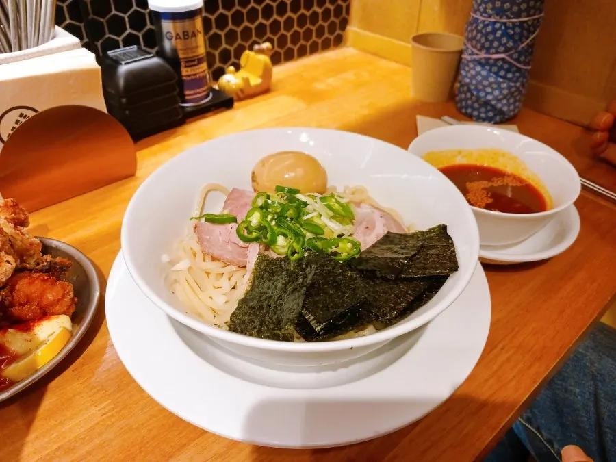 Bowl of cold tsukemen noodles and separate bowl of red sauce