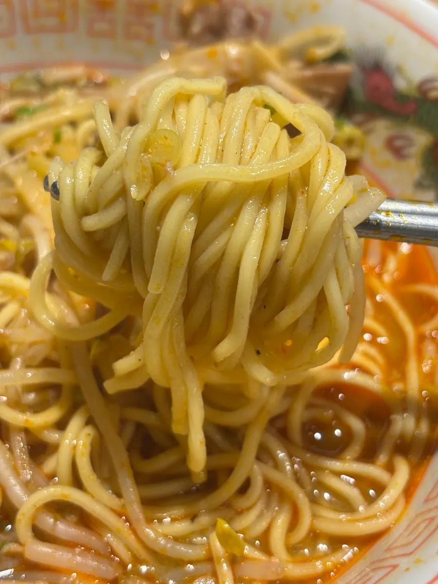 A bite of ramen with brisket and bamboo shoots on top