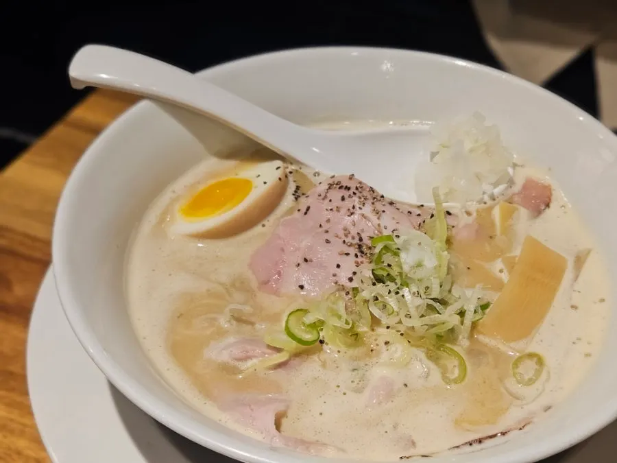 Beef intestine lifted from the motsu ramen with chopsticks