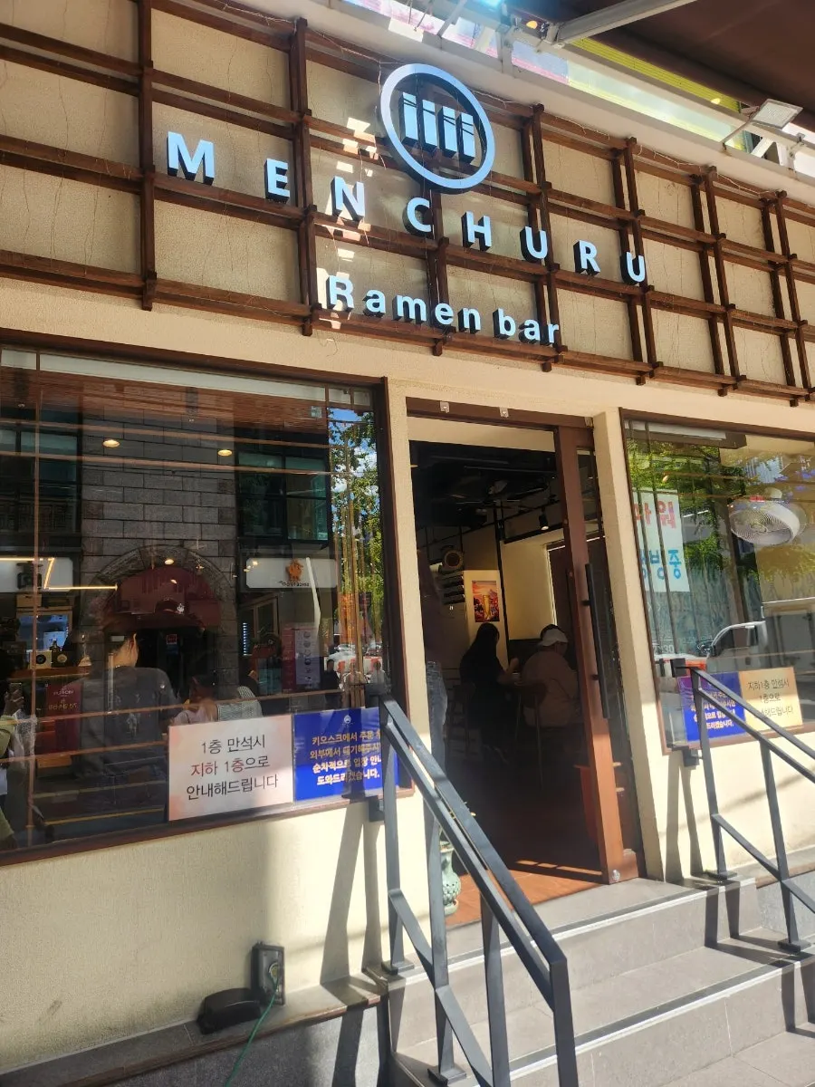 Wood-toned exterior of Mentsuru City Hall Branch at the alley entrance