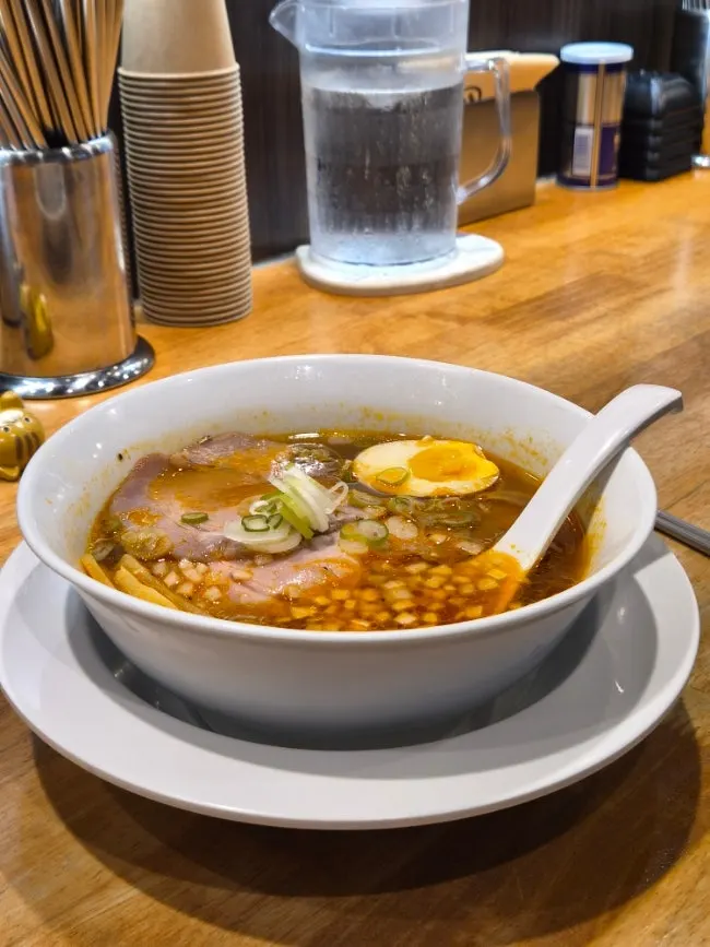 A bowl of spicy soy ramen topped with ingredients
