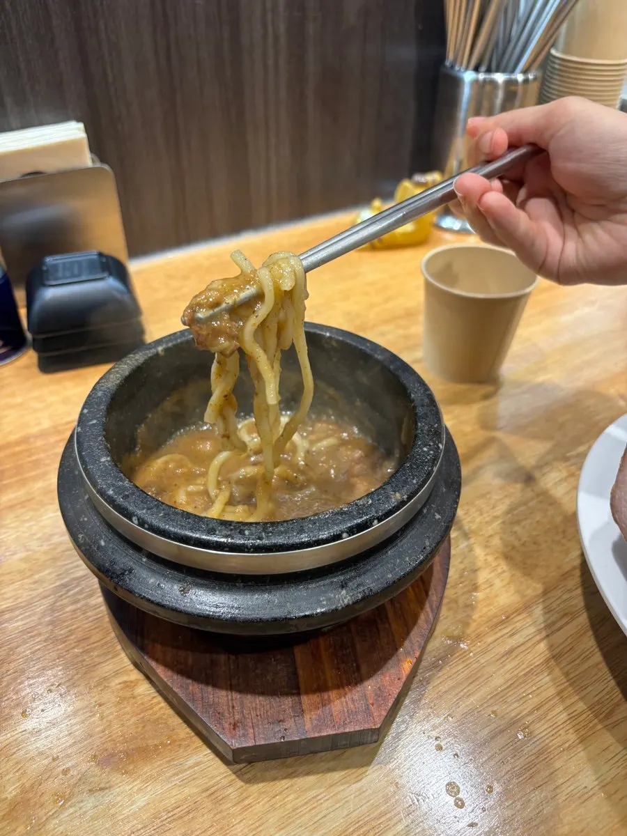 Rich tsukemen broth served in a stone pot