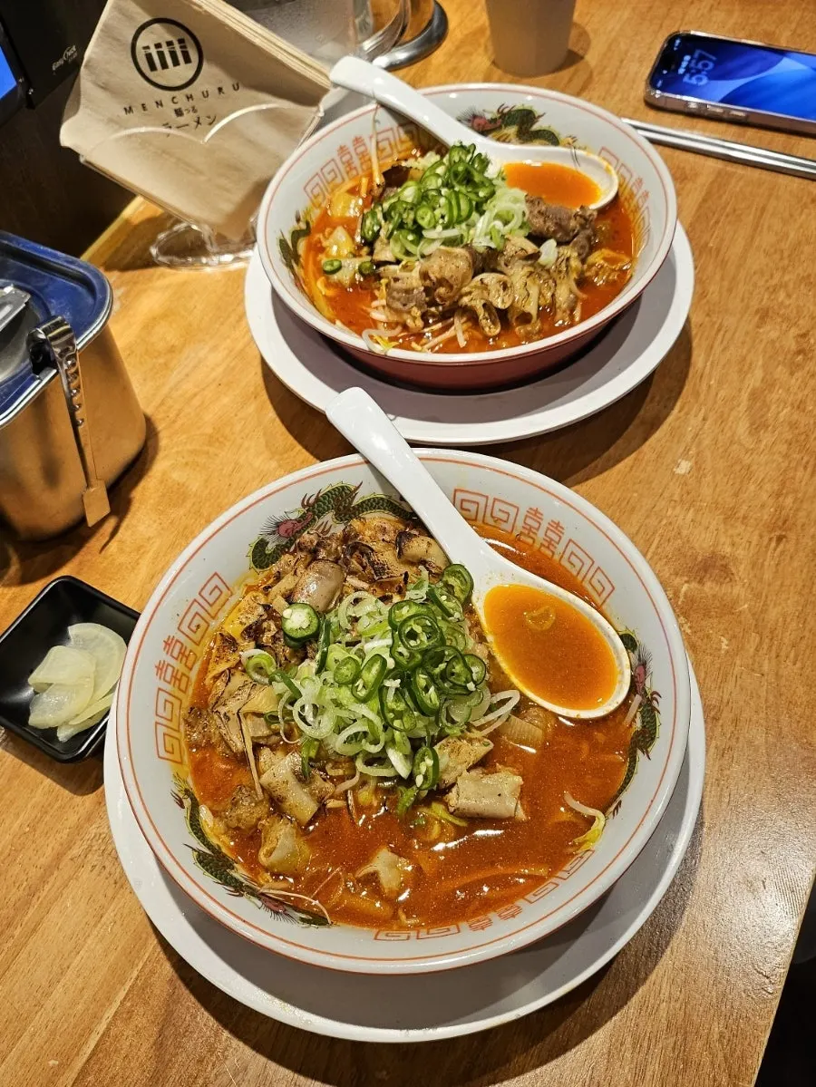 A bowl of Mentsuru motsu ramen piled high with toppings