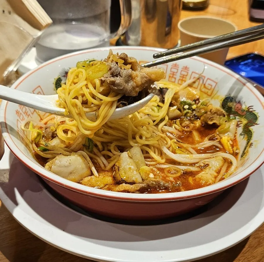 Close-up of motsu ramen toppings in red broth