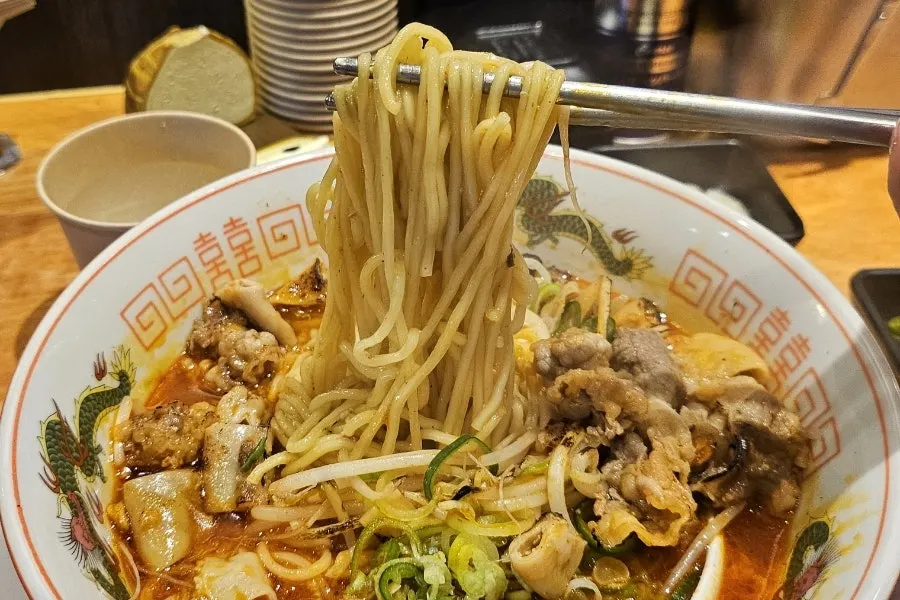 Noodles lifted with chopsticks from the motsu ramen