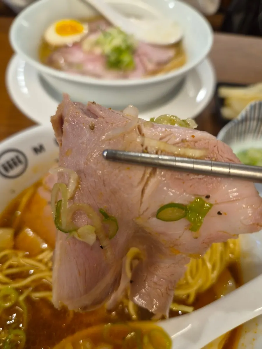 Vertical photo of chewy ramen noodles being lifted