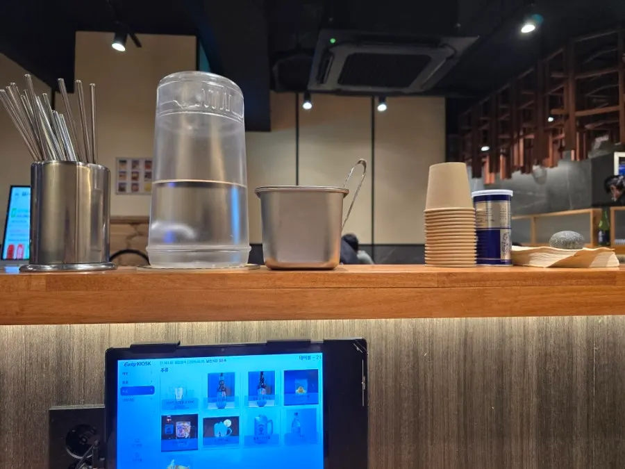 Water, utensils, pepper, and pickled radish on the bar counter