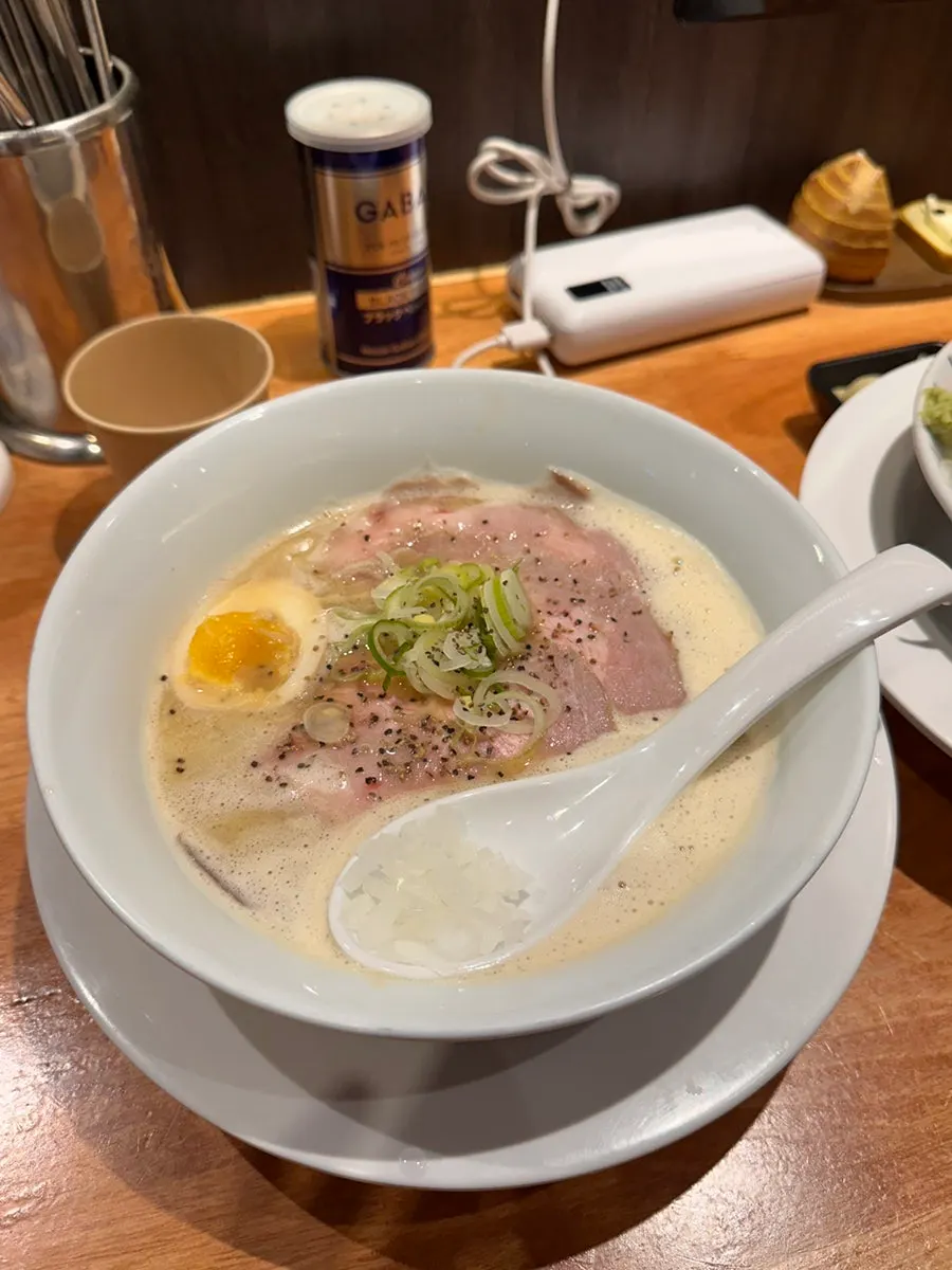 Bowl of tori paitan topped with charshu and a soft-boiled egg