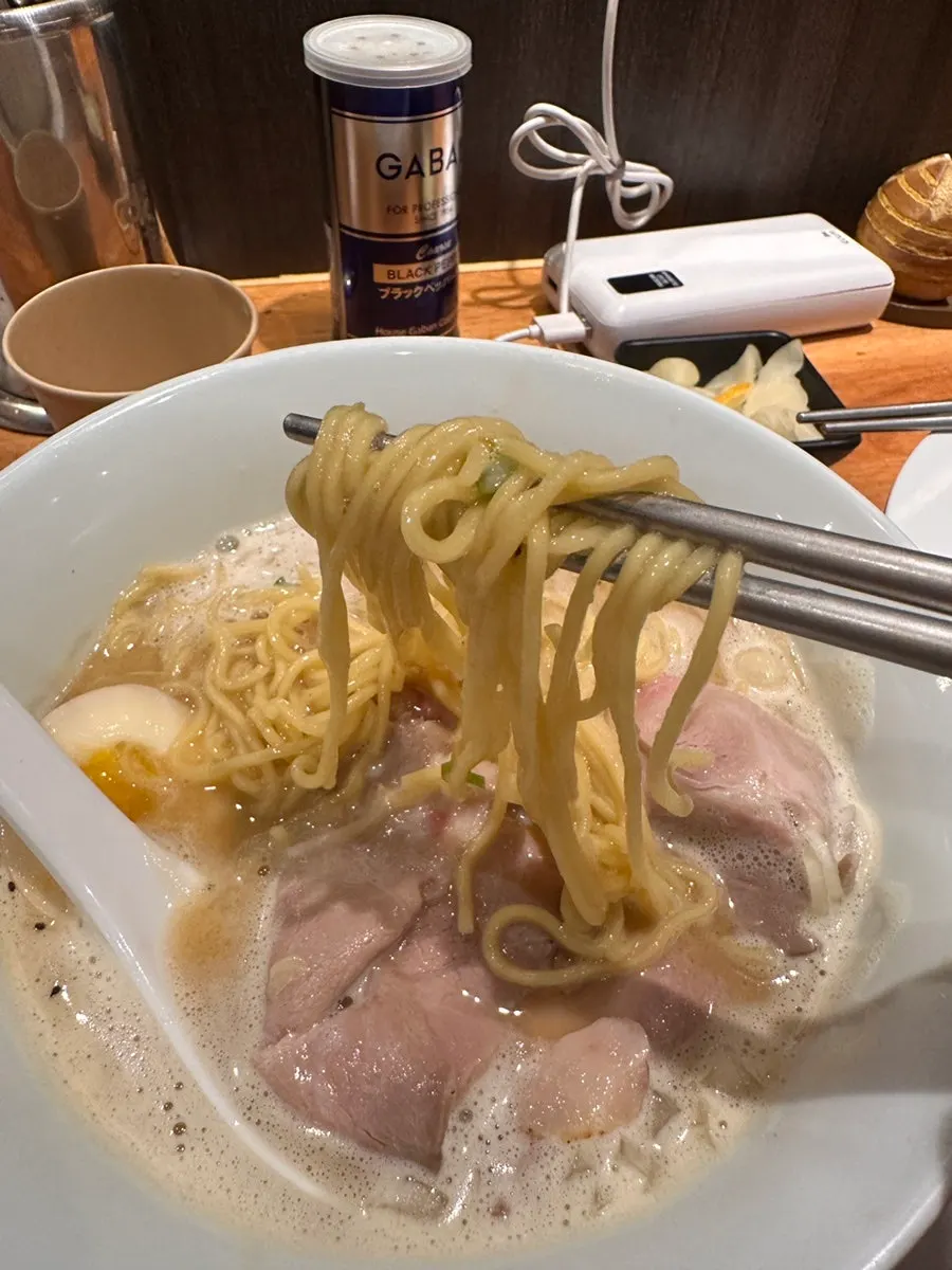Chewy ramen noodles lifted with chopsticks