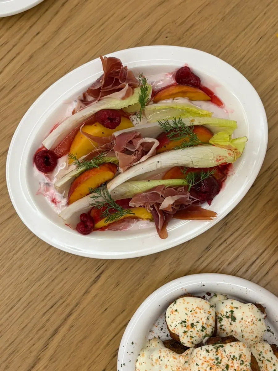 Endive salad topped with jamón and peach