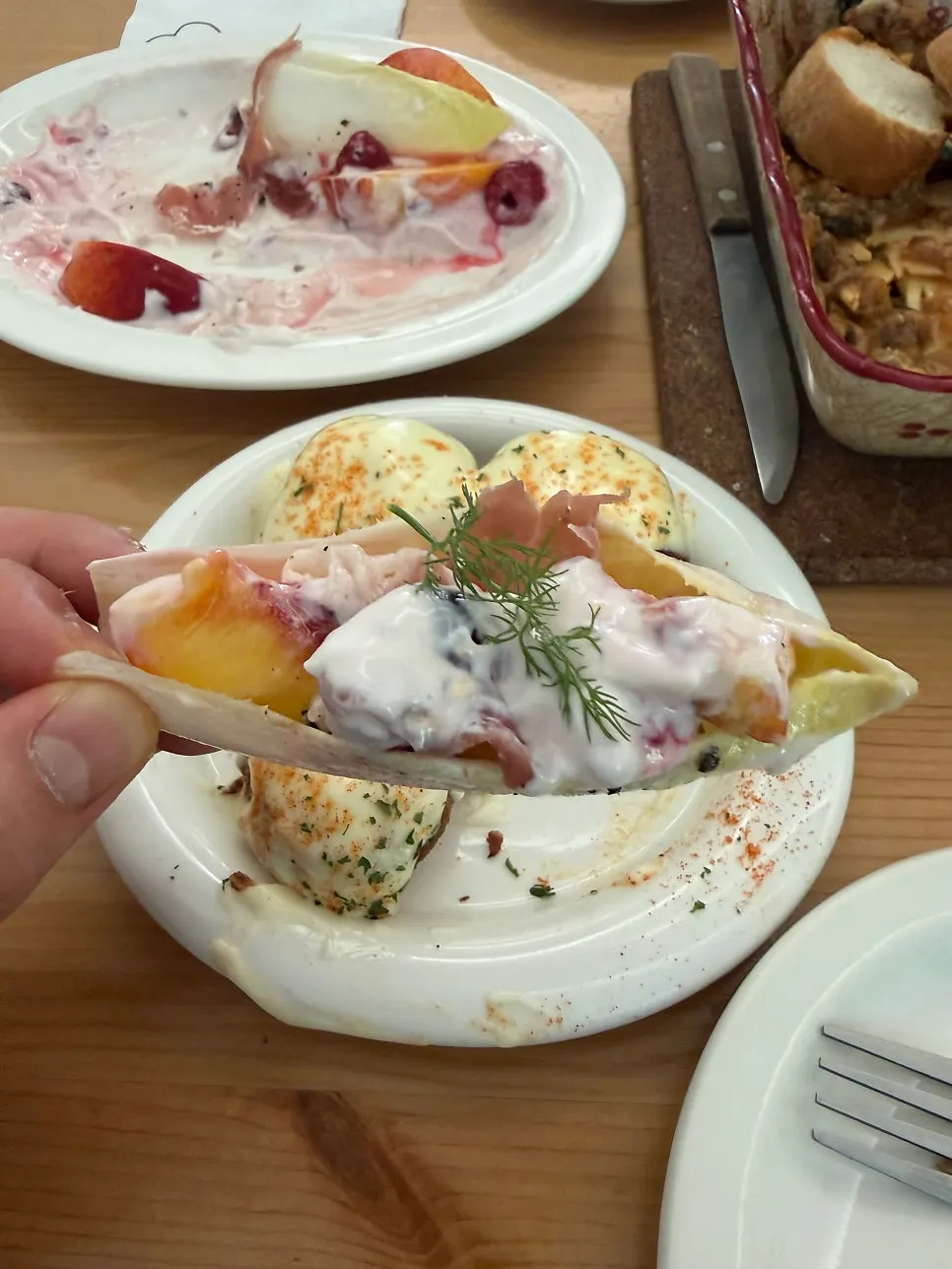 Endive salad topped with raspberry, peach, and jamón