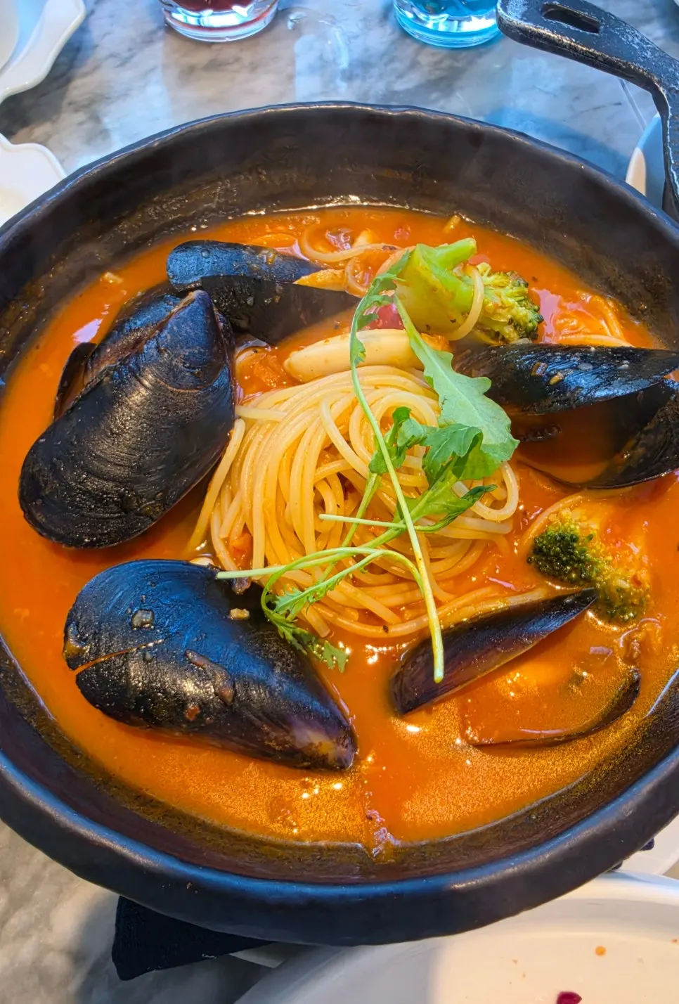 Spicy ppaeswe pasta served in a black pot