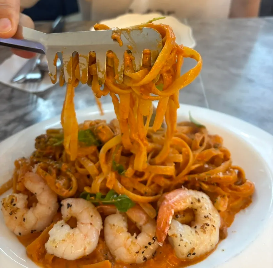 Udang dan mi diangkat bersamaan dari rosé pasta