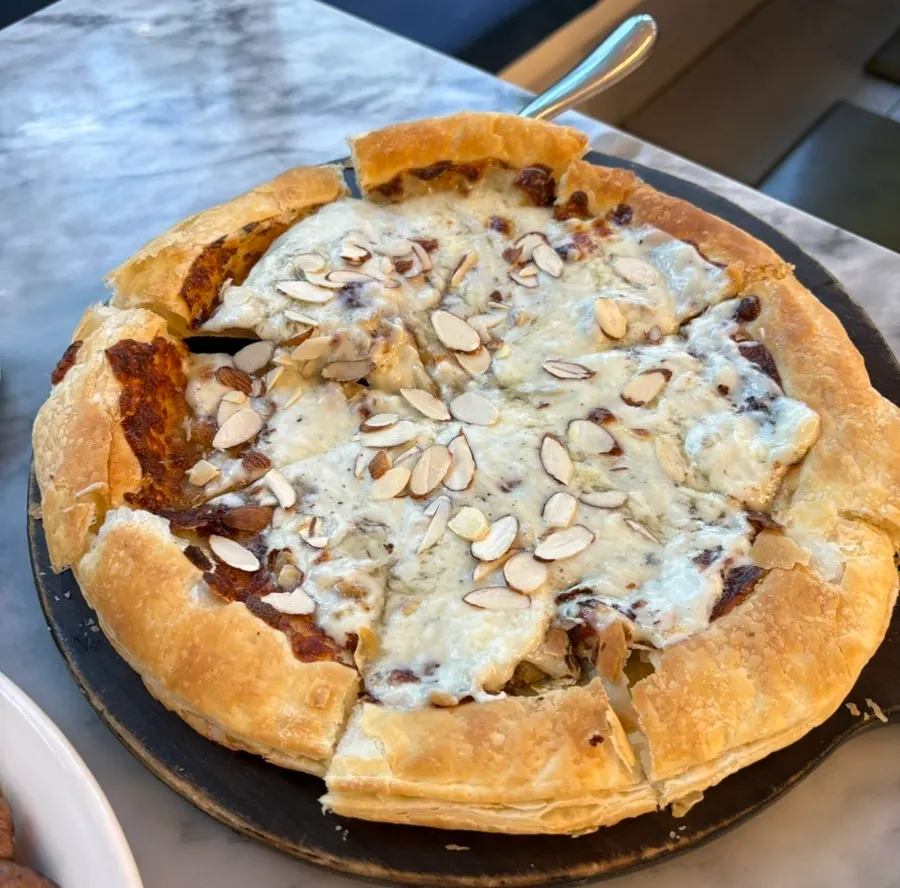 Pizza gorgonzola utuh dengan taburan irisan almond