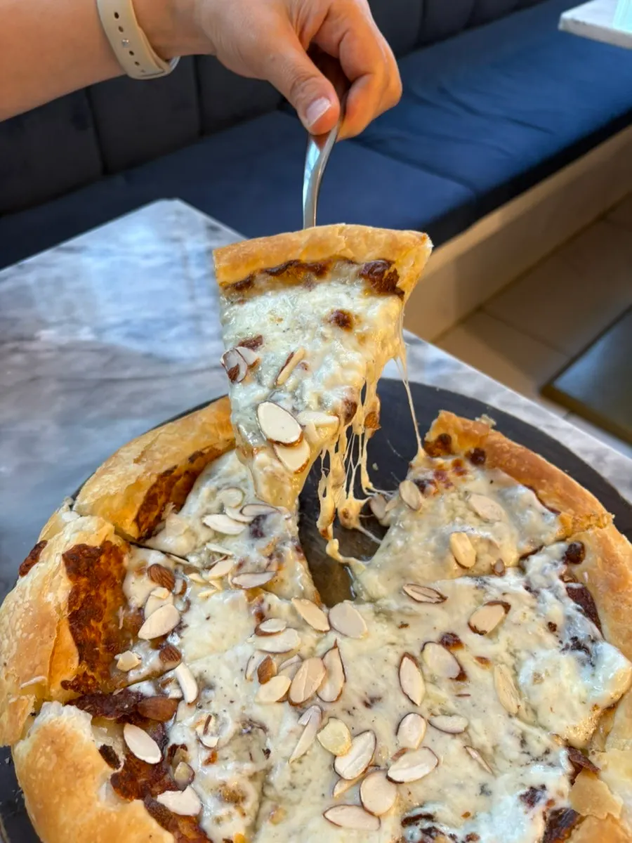 Satu potong pizza gorgonzola diangkat