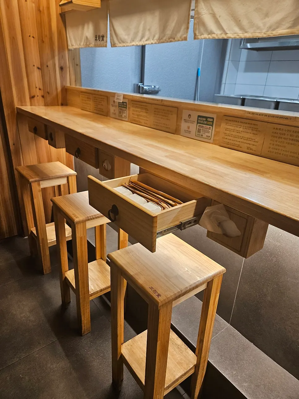 Drawer under the table with spoons and napkins