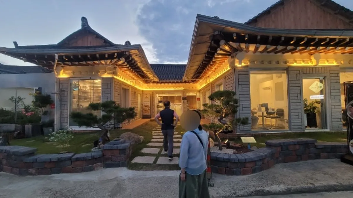 Midam Kitchen's exterior with tiled roof and floor-to-ceiling window