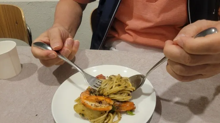 Close-up of basil oil pasta topped with whole shrimp