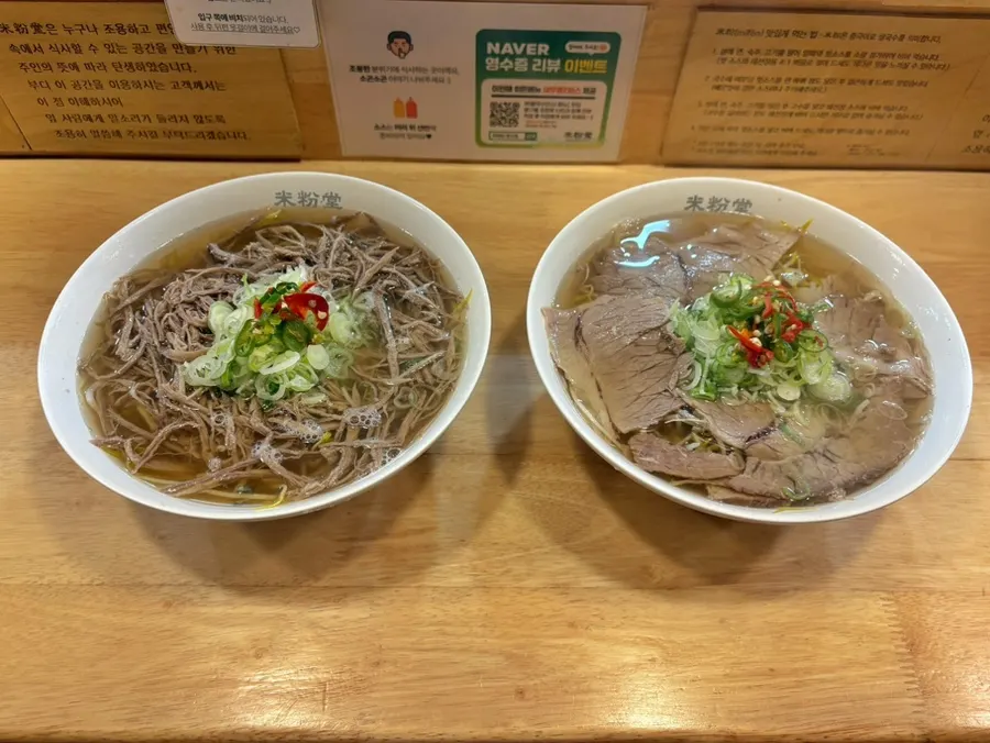Two bowls of pho placed side by side