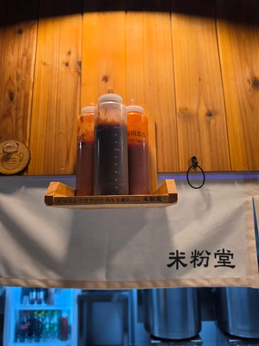 Hot sauce, chili sauce, and hoisin sauce on the table