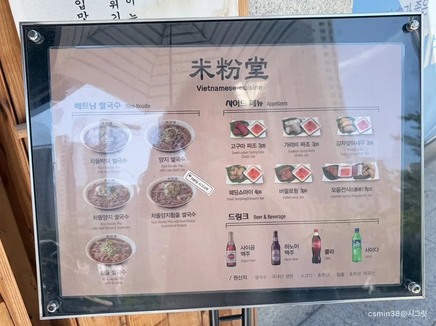 Menu board for pho and side dishes set up in front of the entrance