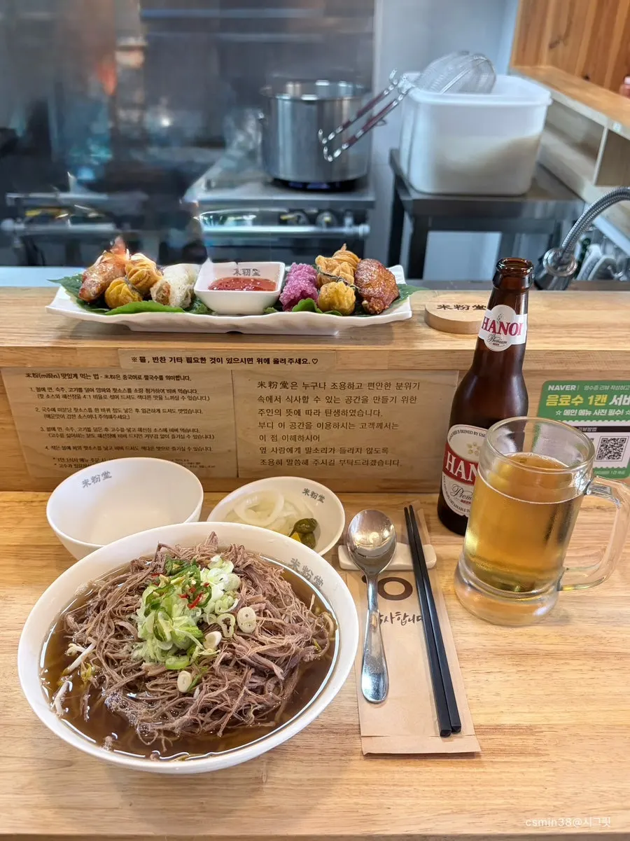 Brisket pho and assorted fried appetizer plate on the table