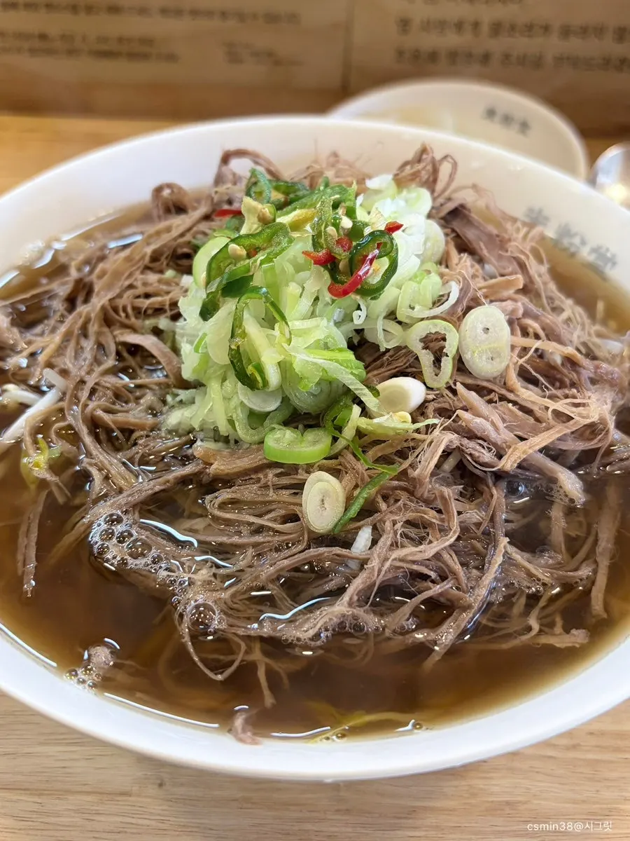 Brisket pho topped with meat and bean sprouts