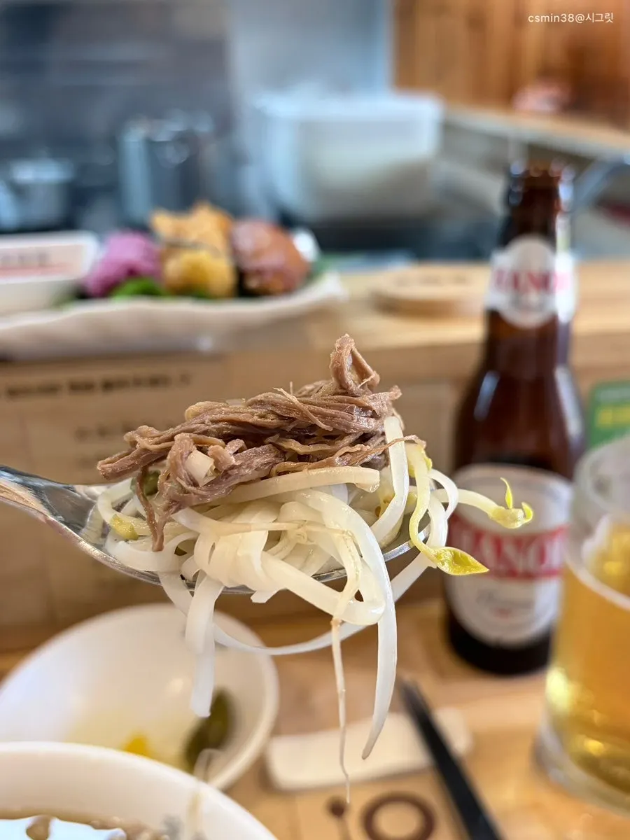 Mixing bean sprouts and meat into the pho