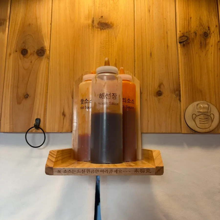 Hoisin sauce, chili, and hot sauce lined up above the seats