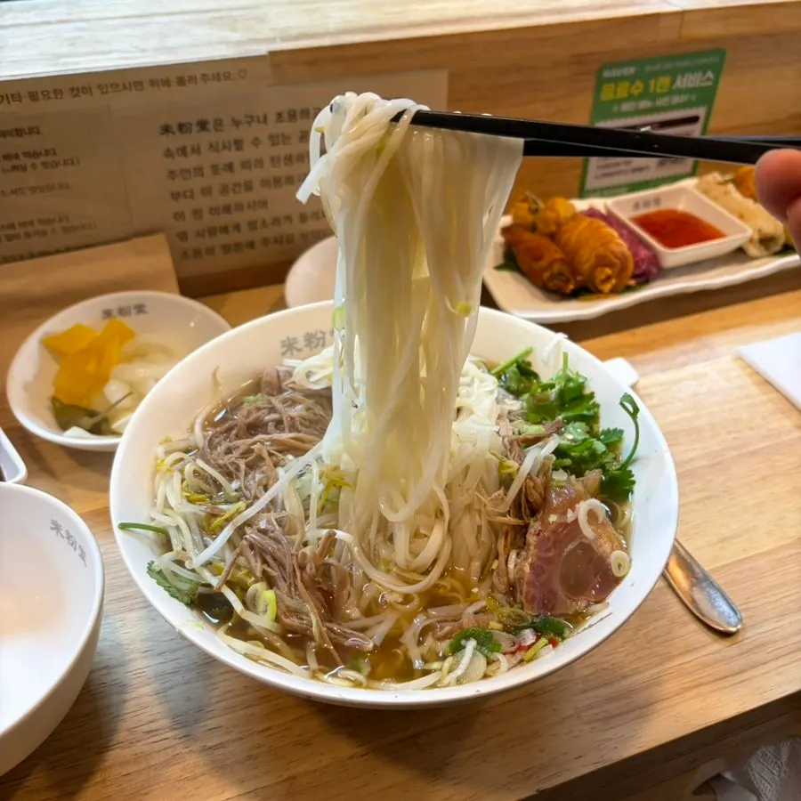 A bowl of pho finished off with sauces