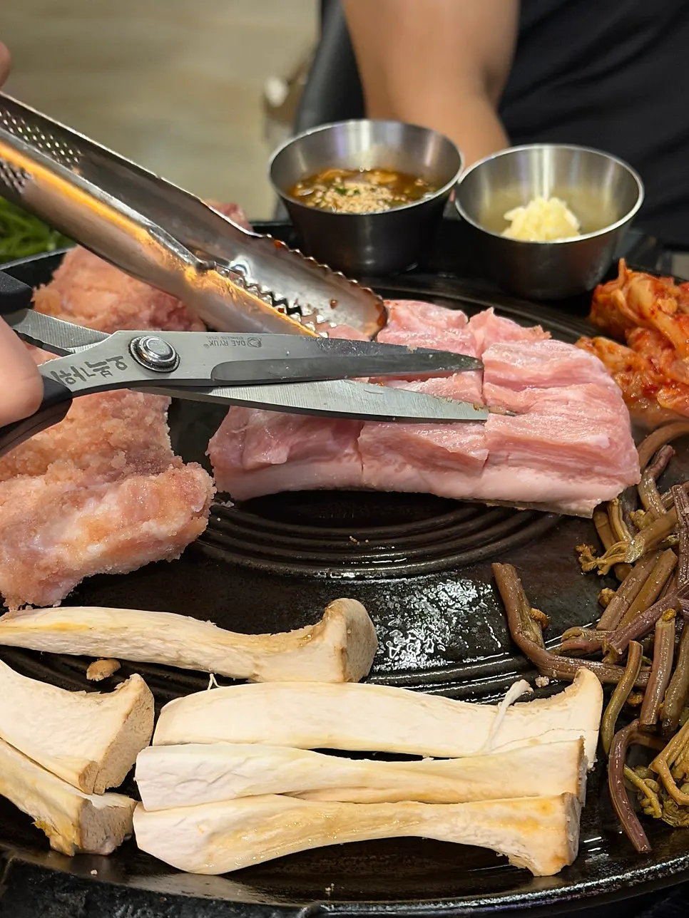 Kimchi and bracken fern grilling alongside the pork belly