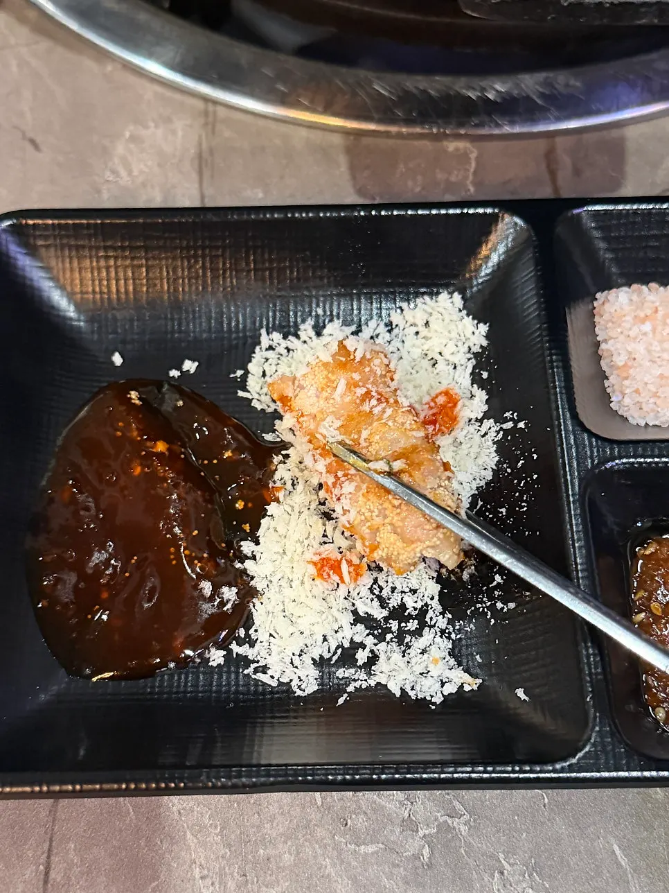 A piece of aged pollack roe pork belly picked up with chopsticks