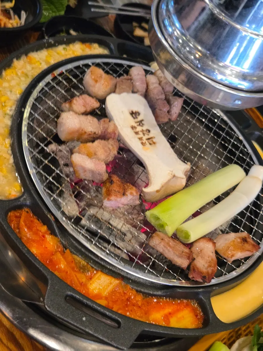 Steamed egg, kimchi, and corn cheese on the side of the grill