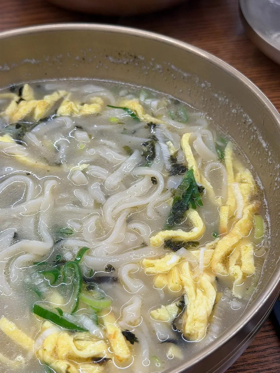 Noodles lifted up from the kal-mandu-guk bowl