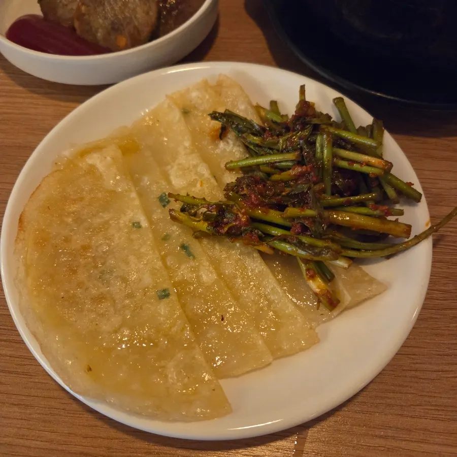 Flat dumplings served with seasoned minari